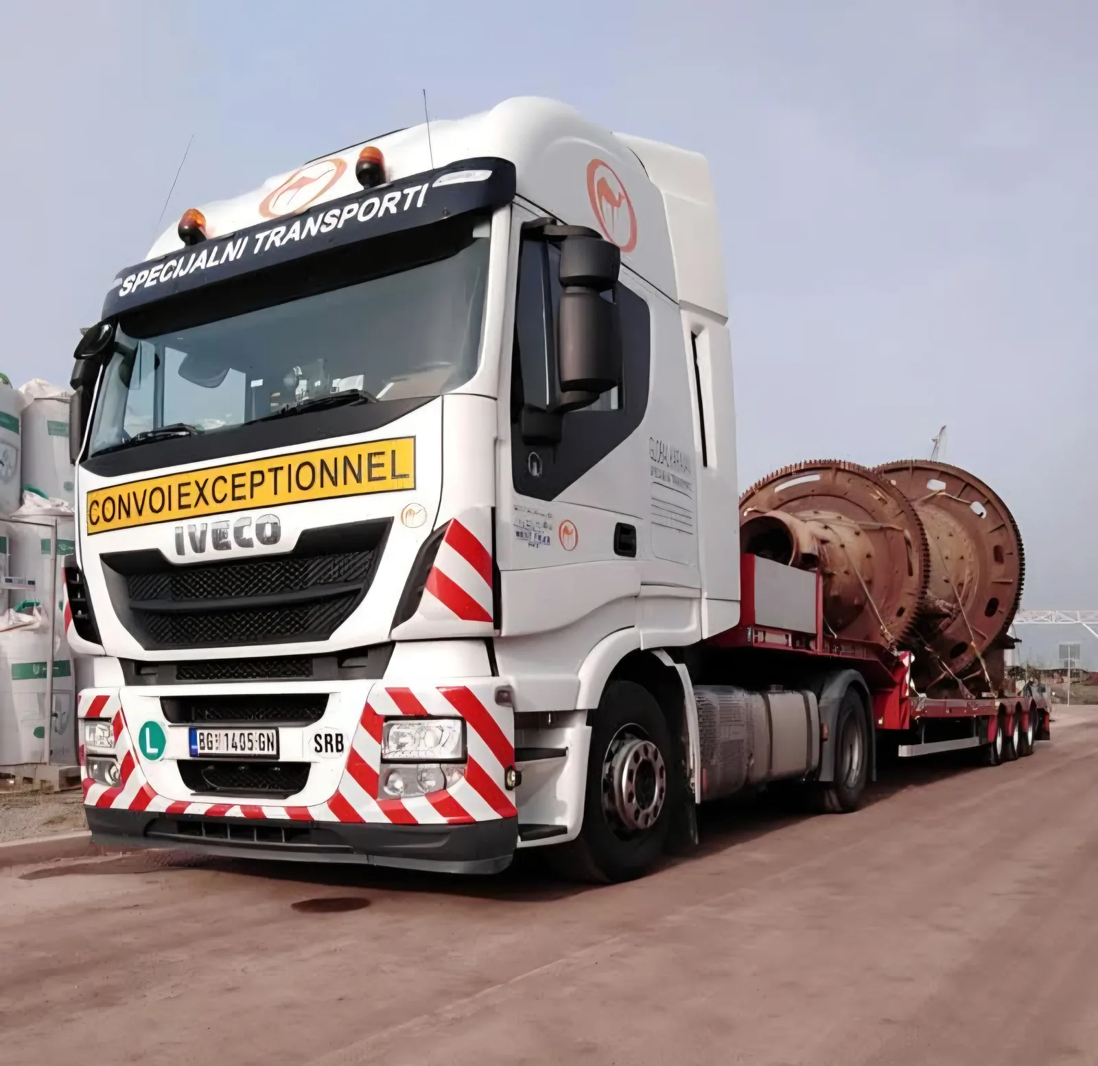 Convoi Exceptionnel tractor hauling large ball-mill drums on a lowboy trailer