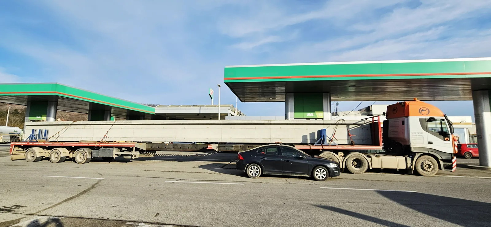 Truck with an extendable trailer hauling a long precast concrete girder